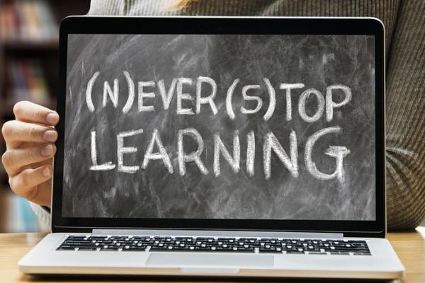 An open laptop which says never stop learning on the screen.