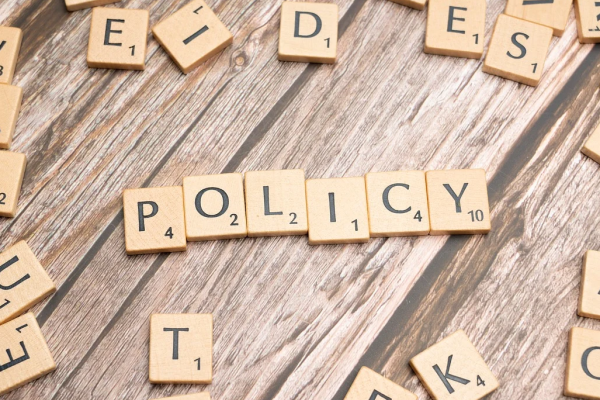 The word policy written using scrabble tiles.