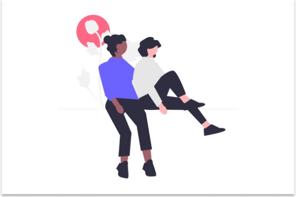 A young dark skinned woman with her hair in a bun sits next to another young woman with short hair. She is protected by the other woman.
